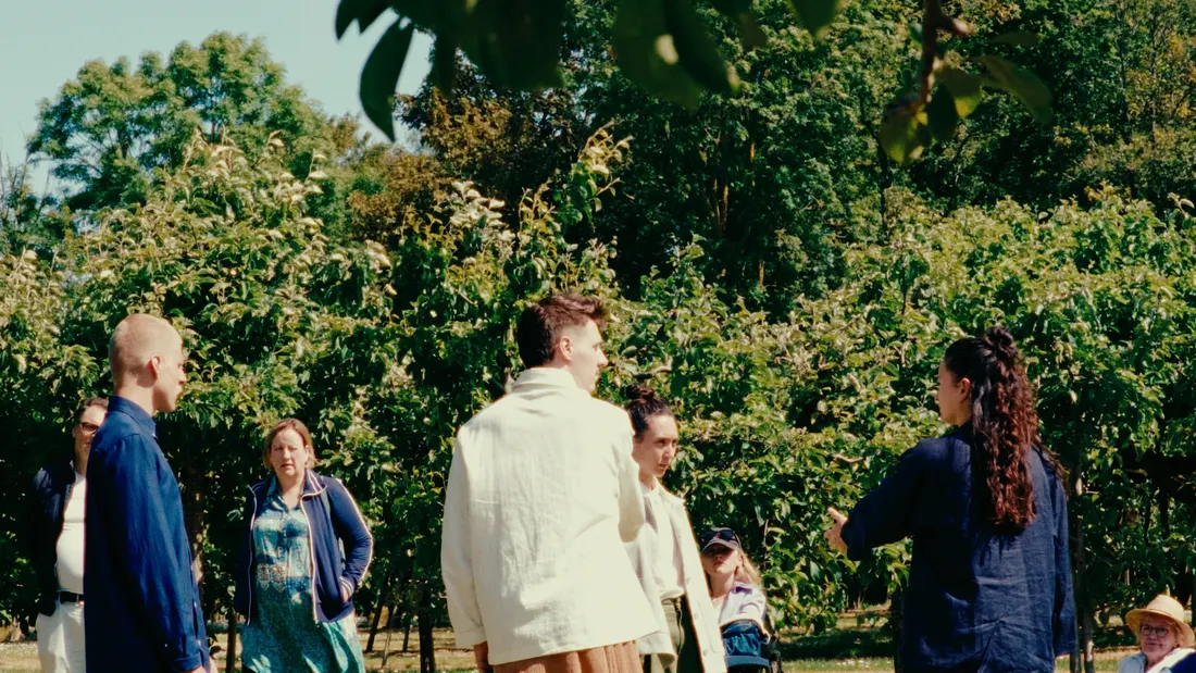 Filmstill, mensen in een boomgaard